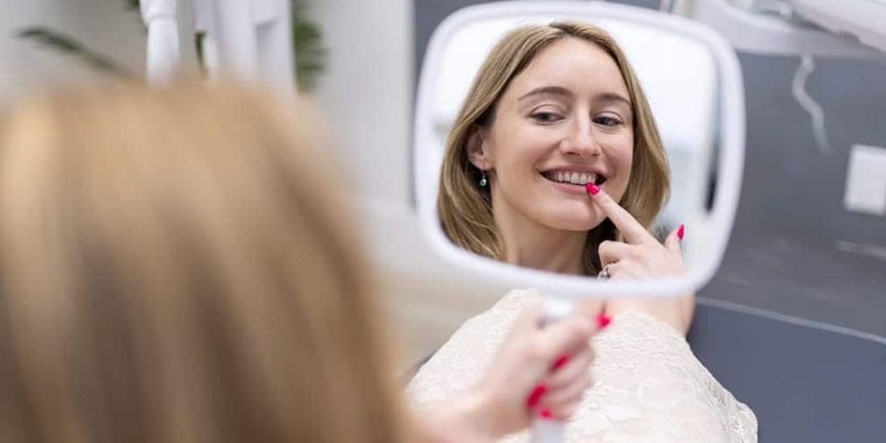 Patient Inspecting Her New Dental Crowns